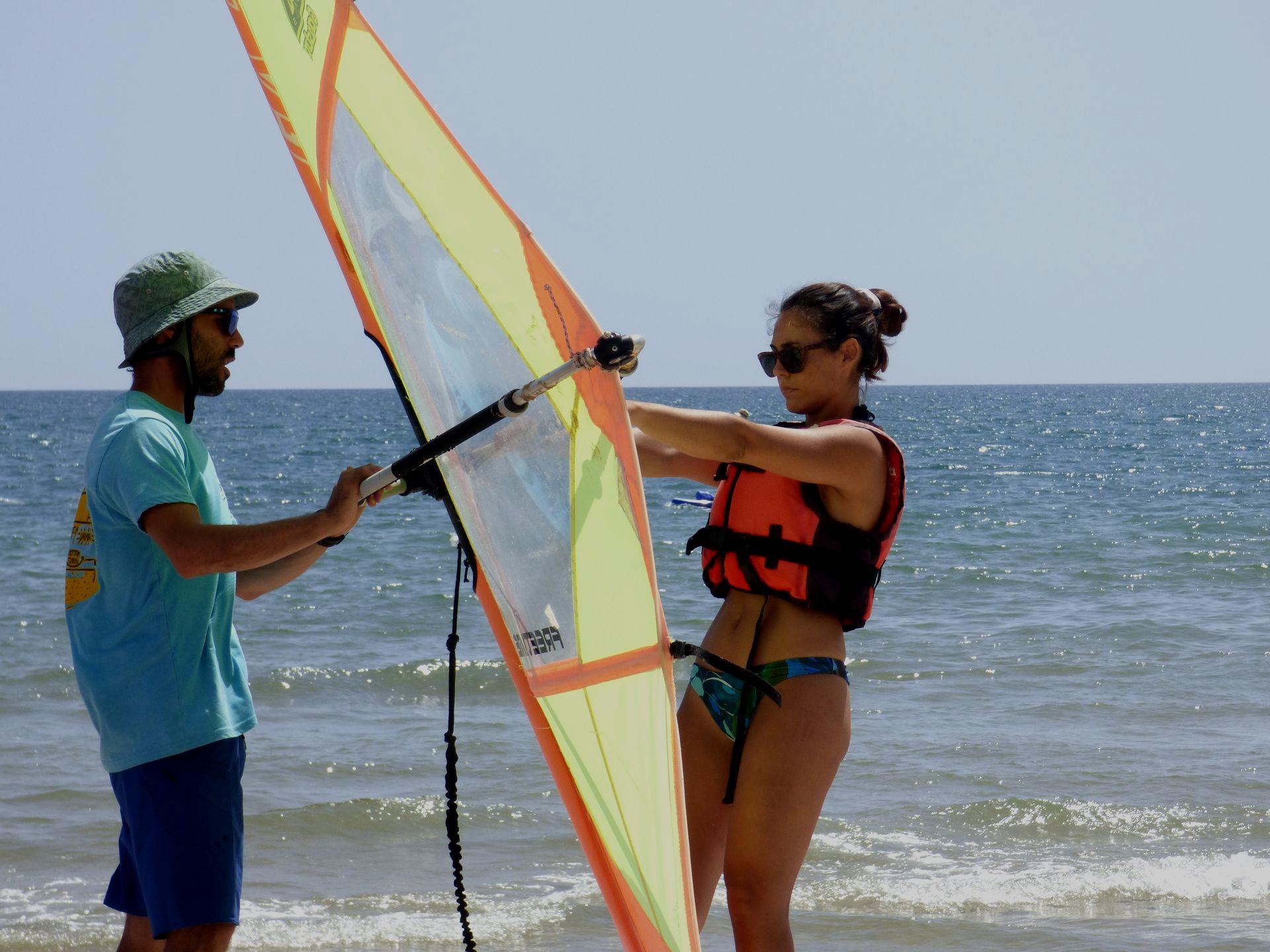 Un instructor de Ohana acompaña una clase de windsurf